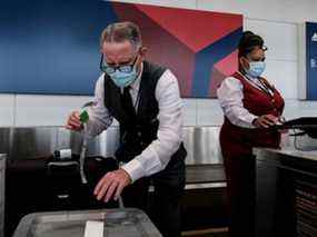 Les employés de Delta Airline enregistrent leurs bagages à l'aéroport national Ronald Regan le 22 juillet 2020 à Arlington, en Virginie.