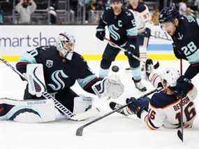 Chris Driedger #60 du Seattle Kraken effectue un arrêt devant Tyler Benson #16 des Oilers d'Edmonton lors de la première période au Climate Pledge Arena le 18 décembre 2021 à Seattle, Washington.