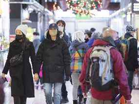 Les gens portent des masques faciaux lorsqu'ils se promènent dans un marché à Montréal le 28 novembre 2021, alors que la pandémie de COVID-19 se poursuit au Canada et dans le monde.