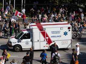 Une ambulance traverse une foule de personnes lors d'un rassemblement anti-vaccins à Vancouver le 1er septembre.