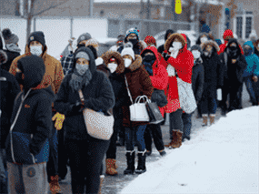 Des gens font la queue pour récupérer des kits de test d'antigène COVID-19 à Ottawa le 21 décembre 2021.