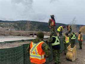 Des membres des Forces armées canadiennes poursuivent la construction de conteneurs Hesco le long d'une section de la rivière Coldwater à Merritt le 1er décembre 2021.