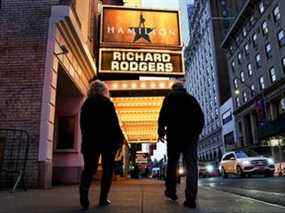 Des gens passent devant le Richard Rodgers Theatre après l'annulation des spectacles de Hamilton broadway en raison de cas révolutionnaires de COVID-19 à New York, le 16 décembre 2021.