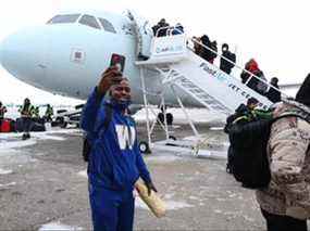 Le demi défensif des Blue Bombers Nick Taylor prend des images alors que l'équipe monte à bord d'un avion à l'aéroport international de Winnipeg hier.