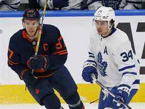 L'attaquant des Oilers d'Edmonton Connor McDavid (à gauche) et l'attaquant des Maple Leafs Auston Matthews cherchent une rondelle libre au Rogers Place à Edmonton.