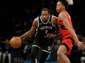 L'attaquant des filets Kevin Durant (7) contrôle le ballon contre l'attaquant des Raptors Scottie Barnes (4) au cours du quatrième trimestre au Barclays Center.