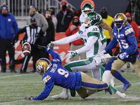 Le demi défensif des Blue Bombers de Winnipeg Nick Taylor, 9 ans, brise une passe qui était destinée au receveur des Roughriders de la Saskatchewan, Mitch Picton.  La déviation de Taylor a assuré une victoire de 21-17 à Winnipeg lors de la finale de la division Ouest de la LCF, dimanche.