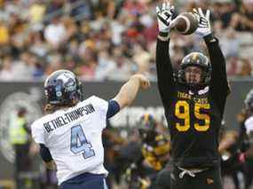 Le quart-arrière des Argonauts de Toronto McLeod Bethel-Thompson s'occupe de l'ailier défensif Julian Howsare des Tiger Cats de Hamilton lors d'un match de la LCF à Hamilton le 11 octobre 2021. Jack Boland/Toronto Sun/Postmedia Network