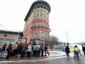 Les clients font la queue devant le Drop-In Centre au centre-ville de Calgary le mardi 21 décembre 2021.