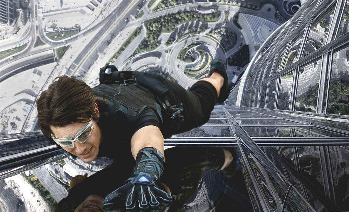 Le super espion du FMI Ethan Hunt escalade le côté d'un immeuble à Dubaï avec des gants magnétiques