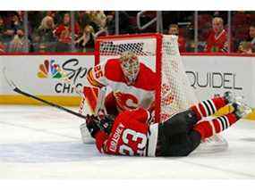 L'attaquant des Blackhawks de Chicago Philipp Kurashev entre en collision avec le gardien des Flames de Calgary Jacob Markstrom après avoir fait trébucher en deuxième période au United Center.  Jon Durr/USA AUJOURD'HUI Sports