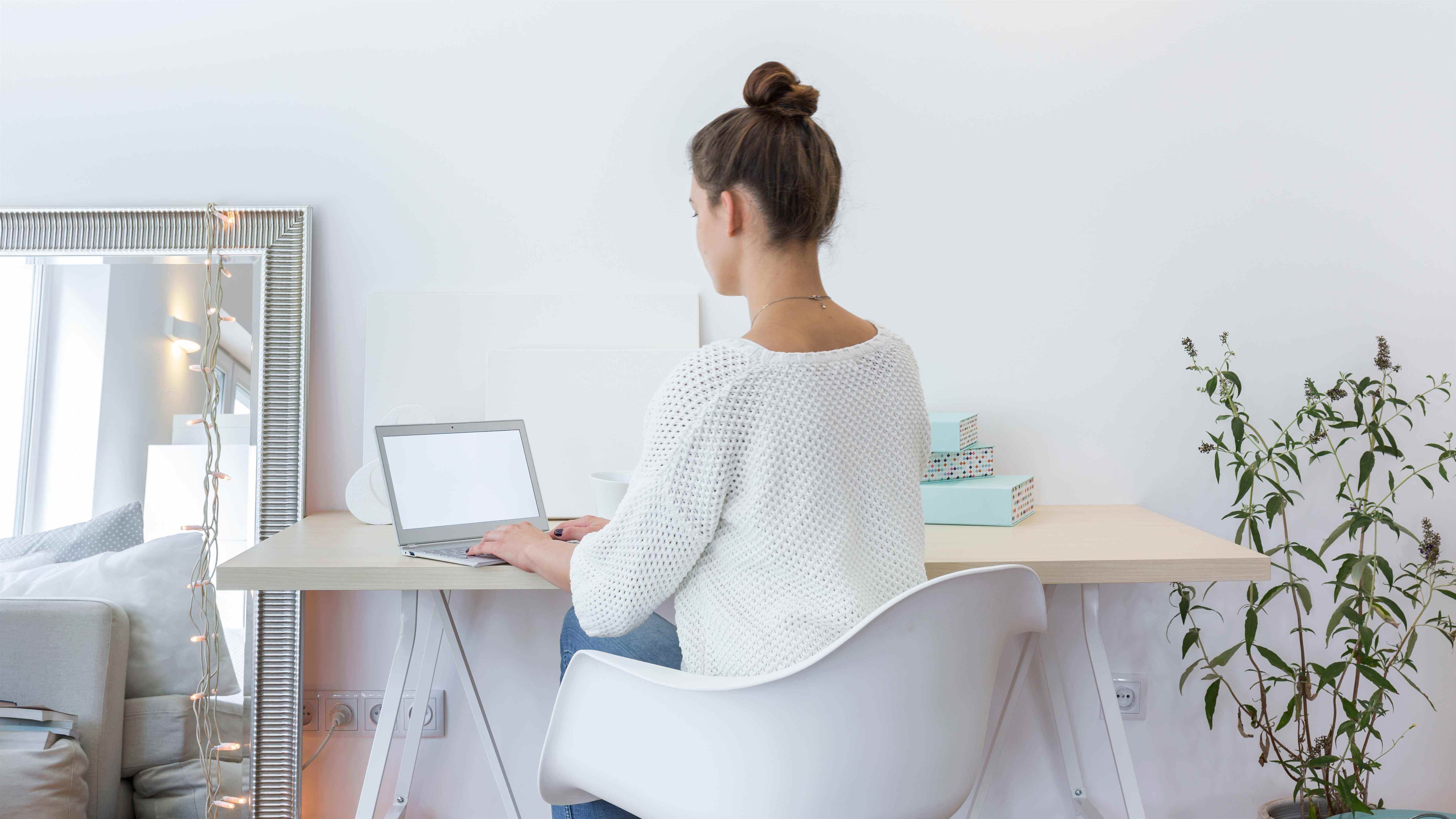 Une femme travaillant dans son bureau à domicile à côté d'un miroir