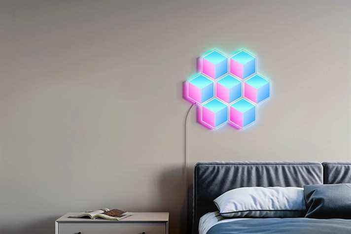 Carrelage mural Govee Hexa cube installé au-dessus du lit.