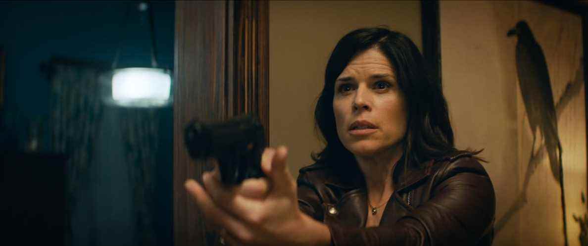 Neve Campbell, l'air paniqué, pointe une arme hors de l'écran dans le cri de 2022