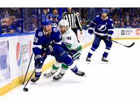 Brayden Point # 21 du Lightning de Tampa Bay et Tyler Motte # 64 des Canucks de Vancouver se battent pour la rondelle lors d'un match à l'Amalie Arena le 13 janvier 2022 à Tampa, en Floride.