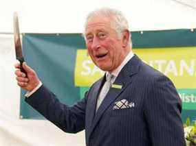 Le prince Charles, patron des samaritains, fait des gestes avant de couper un gâteau lors d'une visite à la branche des samaritains de Gloucester et du district de Gloucester, pour célébrer leur 50e anniversaire à Gloucester, en Grande-Bretagne, le 26 octobre 2021.