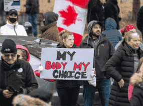 Les gens se rassemblent pour protester contre les mandats du vaccin COVID-19 et les mesures de masquage lors d'un rassemblement à Kingston, en Ontario, le 14 novembre 2021.