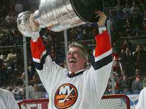 Clark Gillies brandit la Coupe Stanley lors d'une cérémonie honorant le 25e anniversaire de la première victoire des Islanders en Coupe Stanley, avant le match des Islanders contre les Flyers de Philadelphie le 4 mars 2006 au Nassau Coliseum à Uniondale, NY Bruce Bennett/Getty Images .