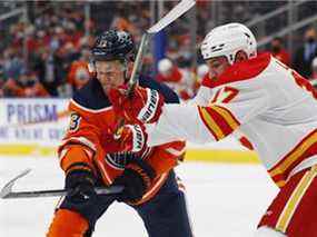 L'attaquant des Oilers d'Edmonton Jesse Puljujarvi et l'attaquant des Flames de Calgary Milan Lucic s'affrontent à Rogers Place à Edmonton le samedi 22 janvier 2022.