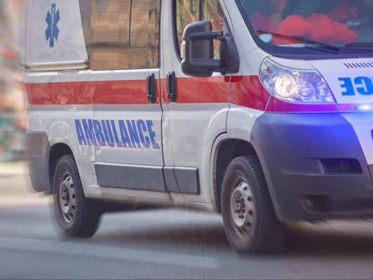 Un homme blessé portant son propre bras sauvé par des travailleurs à proximité