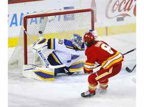 Christopher Tanev des Flames de Calgary marque contre le gardien des Blues de St. Louis Jordan Binnington au Scotiabank Saddledome de Calgary le lundi 24 janvier 2022.