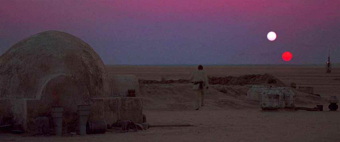 Luke Skywalker marchant vers le coucher de soleil à deux soleils sur Tatooine dans Star Wars : Un nouvel espoir