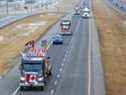 Les camions du «convoi de la liberté» des camionneurs se dirigent vers l'est sur la route transcanadienne à l'est de Calgary le lundi 24 janvier 2022.