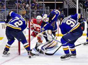 Le gardien de but des St. Louis Blues Ville Husso, le défenseur Justin Faulk et l'attaquant Vladimir Tarasenko défendent le filet contre les Flames de Calgary au Enterprise Center de St. Louis le jeudi 27 janvier 2021.