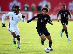 Tajon Buchanan (n ° 11) du Canada et Yunus Musah (n ° 6) des États-Unis se battent pour le ballon lors d'un match de qualification pour la Coupe du monde 2022 au Tim Hortons Field le 30 janvier 2022 à Hamilton, Ontario, Canada.