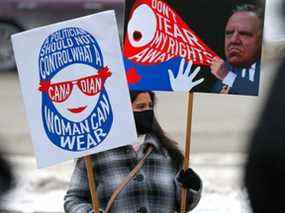 Une femme participe à une manifestation contre le projet de loi 21 du Québec, devant l'hôtel de ville de Calgary, le 19 décembre 2021.