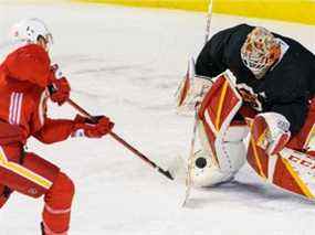 L'attaquant des Flames de Calgary Matthew Tkachuk tire au but tandis que Jacob Markstrom défend lors de l'entraînement au Scotiabank Saddledome le mardi 28 décembre 2021.