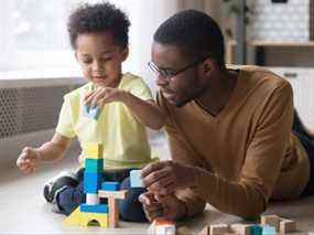 Père et fils africains jouent avec des blocs de jouets colorés