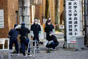 Des policiers inspectent le site où un incident à l'arme blanche s'est produit à une porte d'entrée de l'Université de Tokyo à Tokyo, le 15 janvier 2022.