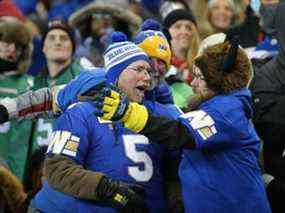 Les partisans des Blue Bombers de Winnipeg célèbrent une victoire contre les Roughriders de la Saskatchewan lors de la finale de la LCF Ouest à Winnipeg le dimanche 5 décembre 2021.