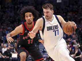 Luka Doncic des Mavericks se dirige vers le panier alors que l'attaquant des Raptors Justin Champagnie défend lors de l'action de la NBA à Dallas, le mercredi 19 janvier 2022.