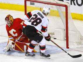 Les Sénateurs d'Ottawa marquent Connor Brown contre le gardien des Flames de Calgary Jacob Markstrom en troisième période dans la LNH au Scotiabank Saddledome de Calgary le jeudi 13 janvier 2022.