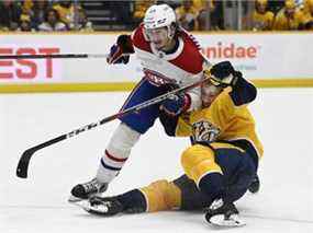 Le défenseur des Canadiens de Montréal Alexander Romanov entre en collision avec le centre des Predators de Nashville Luke Kunin le 4 décembre 2021 à Nashville.