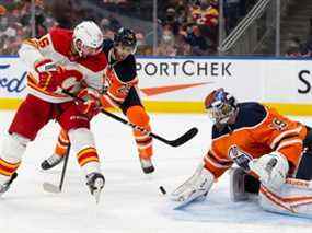 Le gardien de but des Oilers d'Edmonton Mikko Koskinen effectue un arrêt contre Brad Richardson des Flames de Calgary à Rogers Place à Edmonton le samedi 22 janvier 2022.