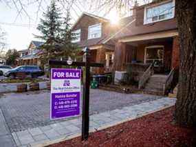 Une enseigne à vendre est affichée à l'extérieur d'une maison à Toronto.