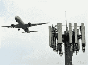 Un United Airlines Boeing 787 Dreamliner vole au-dessus d'une tour cellulaire à l'Aéroport International de Los Angeles.  Aux États-Unis, il y a « un petit bras de fer pour savoir qui décide » entre l'industrie aéronautique et l'industrie des télécommunications, selon un expert.