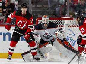 Mike Smith (41 ans) des Oilers d'Edmonton et Andreas Johnsson (11) des Devils du New Jersey gardent un œil sur la rondelle au Prudential Center le 31 décembre 2021, à Newark, New Jersey.