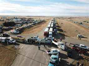 Un convoi de camions et d'autres véhicules bloque la circulation en direction nord et sud sur l'autoroute 4 près de la frontière de Coutts, dans le sud de l'Alberta, le 29 janvier 2022.