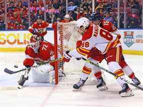 Les Flames d'Andrew Mangiapane des Flames de Calgary centrent la rondelle contre le gardien de but des Panthers de la Floride, Sergei Bobrovsky, au FLA Live Arena de Sunrise, en Floride, le 4 janvier 2022.