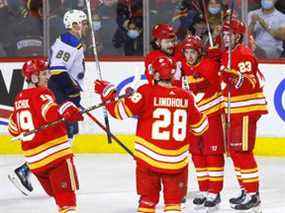 Elias Lindholm des Flames de Calgary célèbre avec ses coéquipiers après avoir marqué contre le gardien des Blues de St. Louis Jordan Binnington au Scotiabank Saddledome de Calgary le lundi 24 janvier 2022.