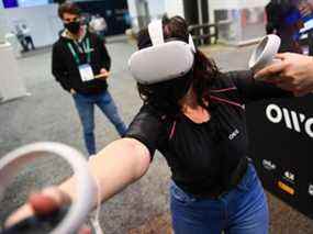 Un participant fait une démonstration du gilet Owo, qui permet aux utilisateurs de ressentir des sensations physiques lors d'expériences de métaverse telles que des jeux de réalité virtuelle, notamment du vent, des coups de feu ou des coups de poing, au Consumer Electronics Show (CES) le 5 janvier 2022 à Las Vegas, Nevada.