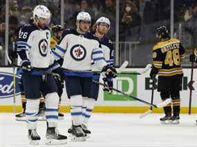 L'ailier droit des Jets de Winnipeg Blake Wheeler (26), le centre Andrew Copp (9) et l'ailier gauche Kyle Connor (81) se dirigent vers le vestiaire après leur défaite 3-2 contre les Bruins de Boston au TD Garden de Boston le 22 janvier 2022 .