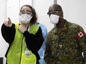 MONTRÉAL, QUÉ. : 10 janvier 2022 -- Camille, une travailleuse de la santé, donne des instructions au caporal Hercules à la clinique de vaccination de la place Décarie alors que l'armée tangue dans les zones touchées par une pénurie de personnel, à Montréal, le lundi 10 janvier. 2022. (Allen McInnis / MONTREAL GAZETTE) ORG XMIT : 67254