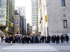 Les piétons traversent la rue Front dans le quartier financier de Toronto.