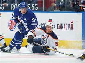 Connor McDavid #97 des Oilers d'Edmonton se bat pour la rondelle contre Auston Matthews #34 des Maple Leafs de Toronto lors de la première période d'un match de la LNH au Scotiabank Arena le 29 mars 2021 à Toronto.