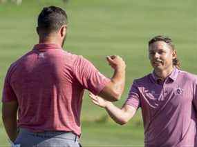 Cameron Smith (à droite) est félicité par Jon Rahm (à gauche) après que Smith a gagné au 18e trou lors de la dernière ronde du tournoi de golf Sentry Tournament of Champions à Kapalua Resort.